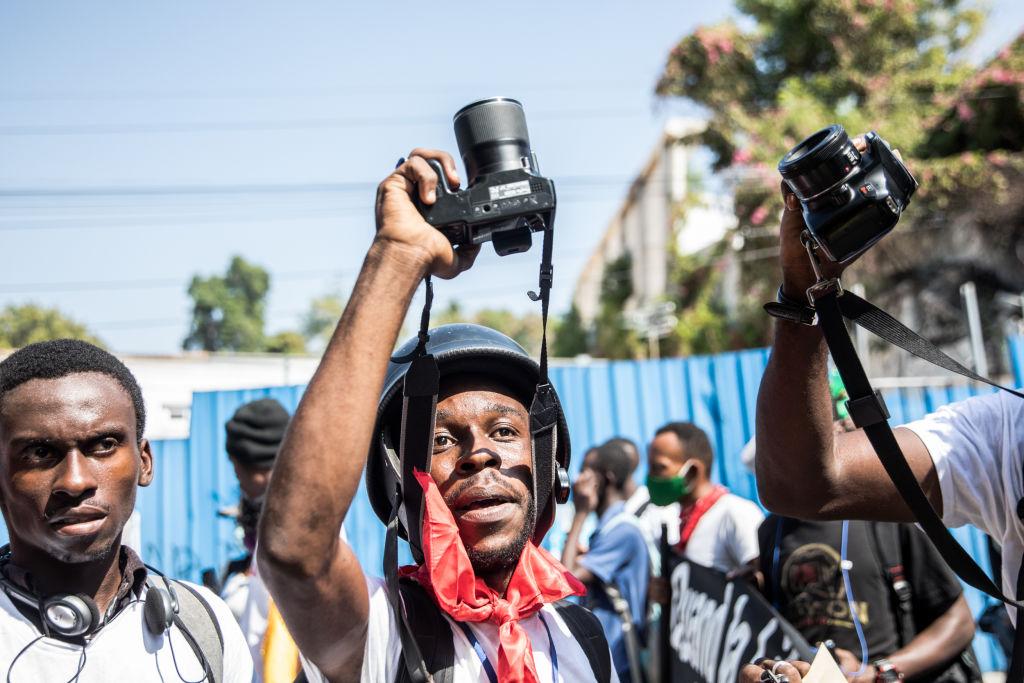 Des photojournalistes haïtiens brandissant leurs appareils lors d'une manifestation