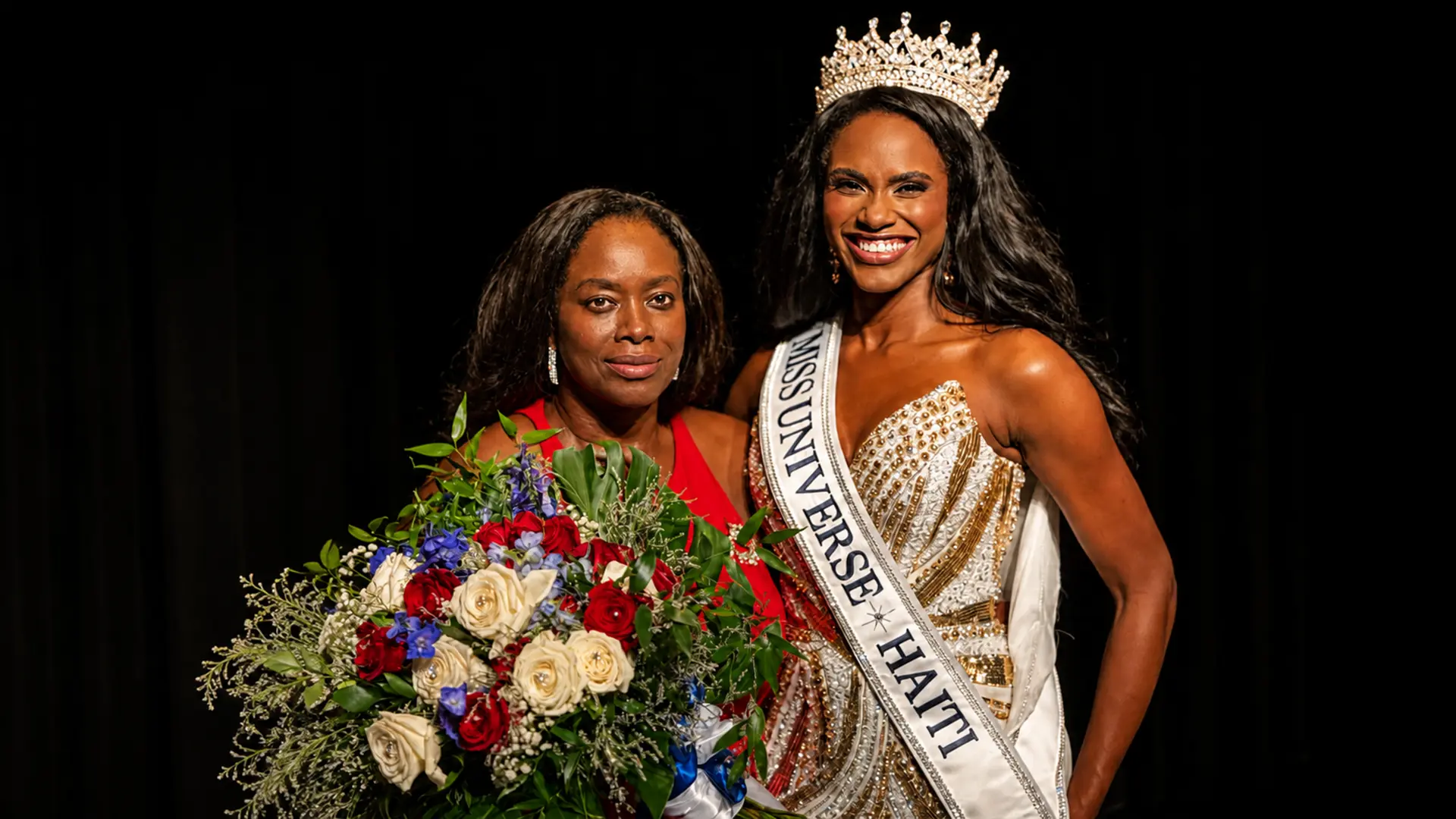 Tatenda Joséphine Rameau posant avec un bouquet aux côtés d'une organisatrice du concours Miss Univers Haïti