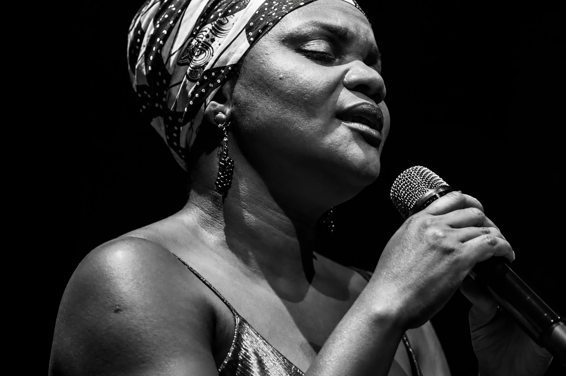 Portrait en noir et blanc de la chanteuse haïtienne Renette Désir au micro